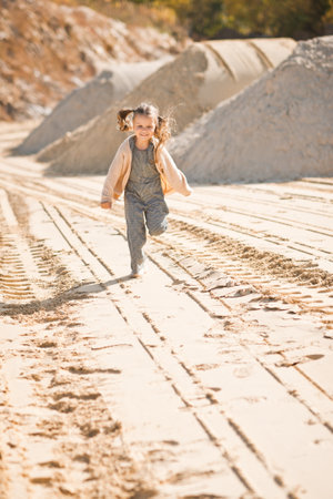 A little girl runs happily among the sand.の写真素材