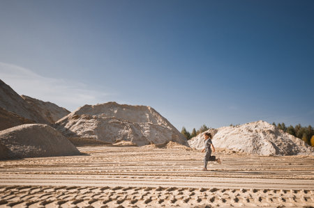 A little girl runs happily among the sand.の写真素材