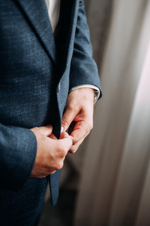The man is buttoning his jacket.