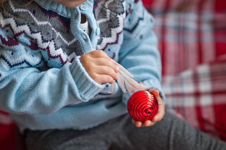 Close-up of children's hands and Christmas tree decorations.の写真素材