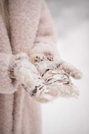 A girl in winter clothes and painted mittens.の写真素材