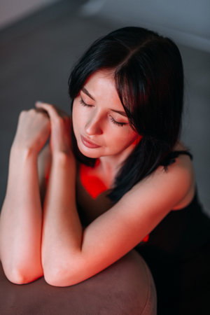 A large portrait of a brunette illuminated by a red lamp.の写真素材