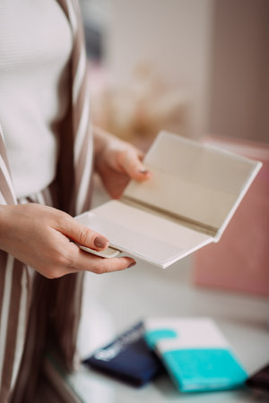 A girl in a business striped jacket presents a book with a handmade cover.の写真素材