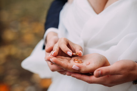 Hands with wedding rings hug each other.の写真素材