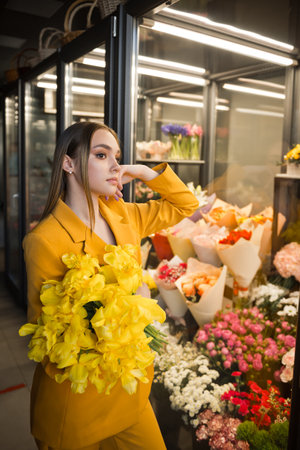 A woman holding a bouquet of flowers indoors.の写真素材