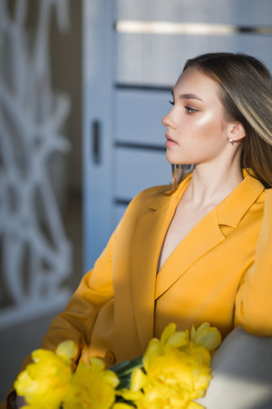 A young girl with a bouquet of yellow tulips.