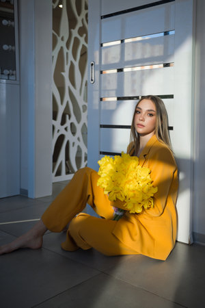A young girl with a bouquet of yellow tulips.の写真素材