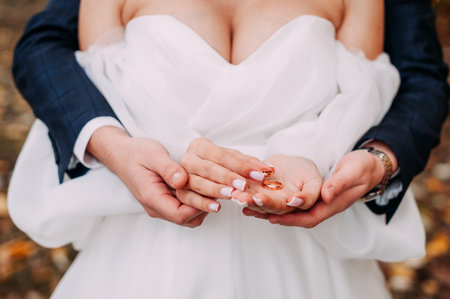 Hugging hands with rings of the newlyweds.の写真素材