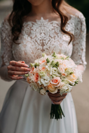 The bouquet contains roses and the woman is outdoors.の写真素材