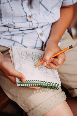 The photo shows a woman writing something with a pen or pencil on a sheet of paper.の写真素材