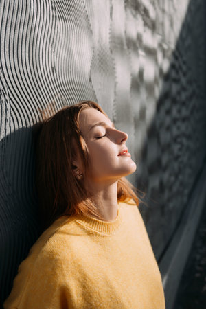 He is outdoors and the sun is shining. The man has a portrait with a redhead.