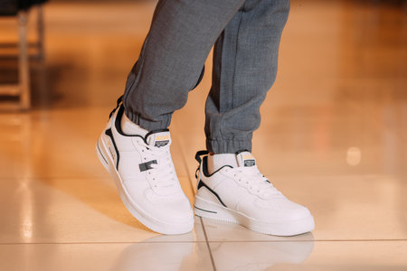 A persons feet wearing white shoes.