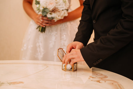 The woman is wearing a wedding dress and holding a bouquet of flowers. The couple appears to be at a...