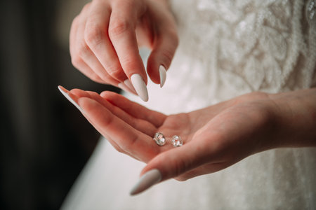 The hands are likely of a bride wearing a wedding dress. The focus is on the ring being displayed, possibly a wedding ring. The setting appears to be indoors, likely during a wedding ceremony.の写真素材