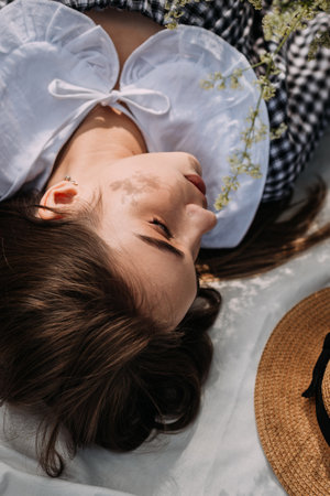 The woman is wearing a hat and appears to be resting peacefully.の写真素材