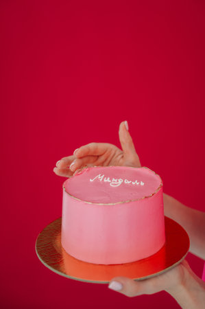 It may be a dessert like a birthday cake or wedding cake, with pink icing and decorations. The image...