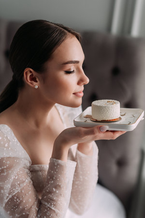 The woman appears to be a bride and is indoors. She is wearing a gown and is standing in front of a wall.の写真素材