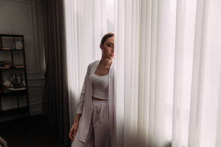 The background includes a wall, a window with a curtain, and a floor.の写真素材