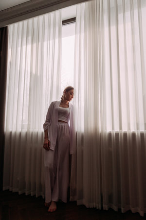 The background includes a wall, a window with a curtain, and a floor.の写真素材