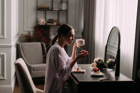 The room contains furniture like a mirror, window, table, chair, and a vase. The woman appears to be wearing wedding attire.の写真素材