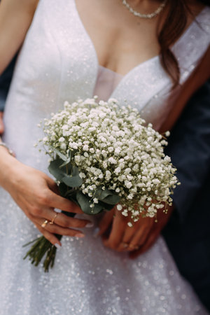 The woman is wearing a wedding dress and holding a bouquet. The setting appears to be outdoors, likely at a wedding ceremony.の写真素材