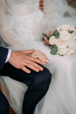 The woman is wearing a wedding dress and veil, holding a bouquet of flowers. The scene indicates a wedding ceremony or celebration.の写真素材