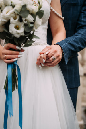 The woman is likely a bride and is holding a bouquet of roses. The setting appears to be outdoors.
