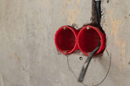 Wiring electrical cables on the wall in the apartment. apartment renovation. Unfinished electrical...
