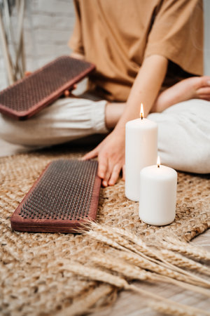 The girl is holding a Sadhu Board in her hands. close-up. white candles. Concept on healthy lifestyle.の写真素材