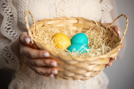 The girl holds a wicker basket with painted eggs. Easterの写真素材