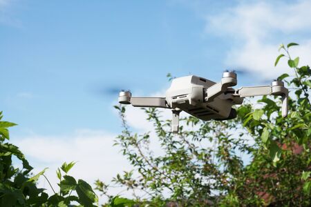 Drone in flight in motion against a blue skyの写真素材