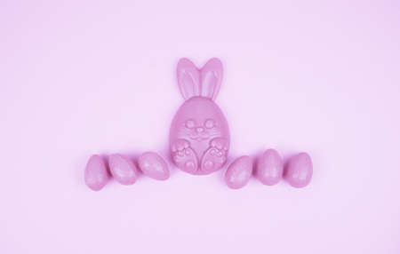 Beautiful Easter composition with Easter cake, chocolate eggs and a hare on a colored background.の写真素材