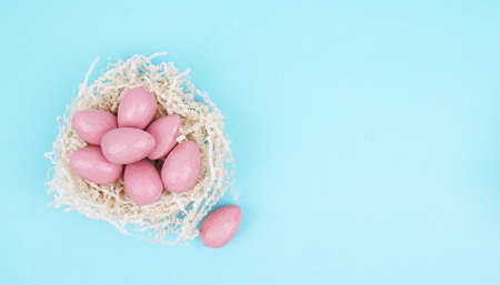 Beautiful Easter composition with Easter cake, chocolate eggs and a hare on a colored background.の写真素材