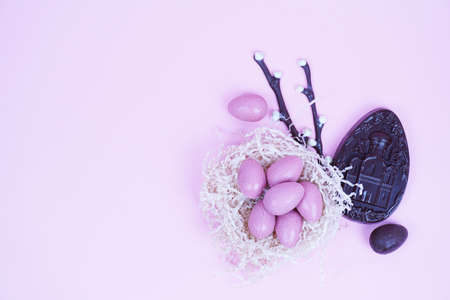 Composition of chocolate figurines. Chocolate bunny. Chocolate eggs on a colored background. Place for the testの写真素材