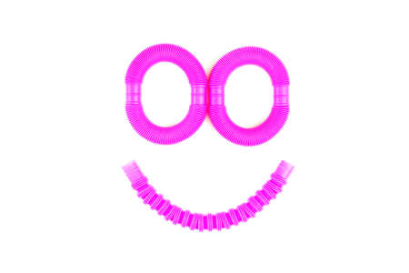 Smile from plastic corrugated tube, pop tube. trending toy of 2021.anti-stress sensory plastic toy from a tube of pink and blue color on an isolated white background. Flat lay with place for text.の写真素材
