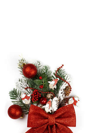 Christmas decoration is a symbol of the new year: a spruce branch with cones sprinkled with snow and decorated with balls, beads and a bow. New Year's bouquet. isolated. Copy space. Flat layの写真素材