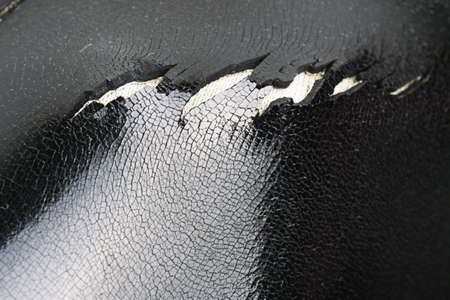An old rubber boot with a hole and cracks in the rubber. The quality of the shoes. Shoe repair. The texture of the structure of cracked rubber. Hole in the bootの写真素材