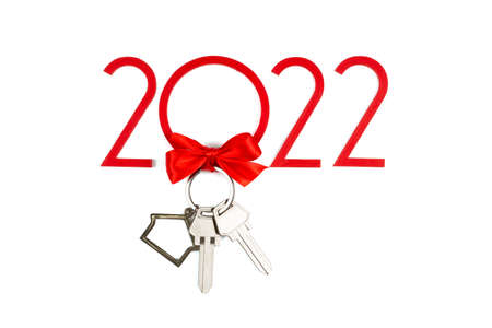 Banner with keys and with a keychain on an isolated white background. House with a red bow. New Years gift for 2022の写真素材