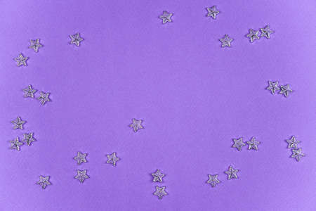 Purple, lilac background with scattered stars. Festive background. trending color 2022. copy space, flatlay. Festive christmas, birthday, event, valentines day backgroundの写真素材