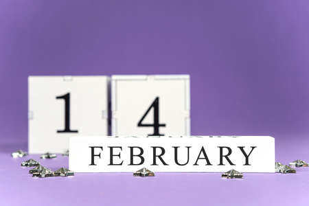 Valentines Day purple, lilac trendy background perpetual calendar white block with the date February 14, a scattering of silver stars.の写真素材