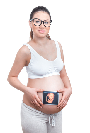 Pregnancy woman with 4d x-ray of fetus or newborn baby. Expectant mother after examination by a doctor gynecologist, isolated on whiteの写真素材