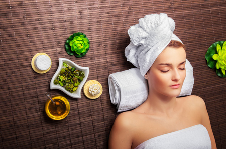 Young beauty woman in a spa with closed eyes. Above viewの写真素材