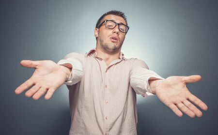 Indigence. I have nothing, young man with outstretched arms over dark gray background. Funny guy or businessman showing his palm - empty hands. Studio shotの写真素材