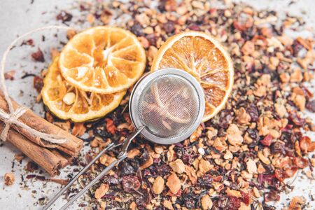Fruit tea of dried flowers petals and berries with cinnamon, dry slice of orange and strainer - filterの写真素材