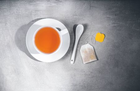 Cup with teabag and spoon. Top view. Tea making concept. Isolated on gray. Top view