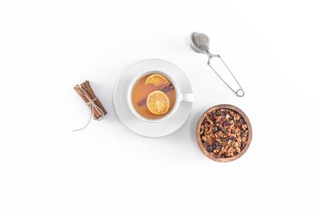 Fruit tea with cinnamon and dried orange in cup - teacup with strainer - filter isolated on white background. Top view, overheadの写真素材