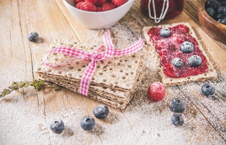 Decorated sweet breakfast with berries and toast over wooden table. Powdered sugarの写真素材