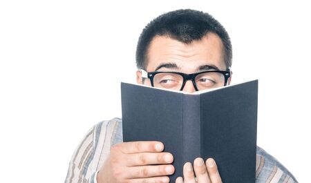 Funny man with book looking to side. Lazy college student, isolated on white background, studio...