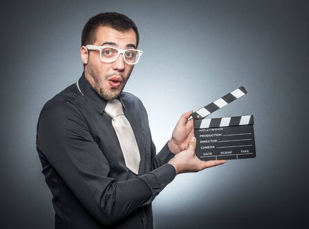 Joyous man with movie clapper board, isolatedの写真素材