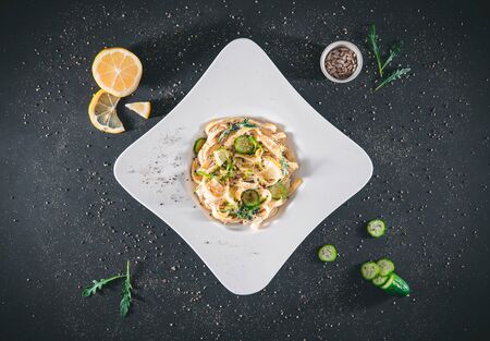 Pasta with a sour cream lemon and herbs, isolated on gray - black  background. Top viewTagliatelle...